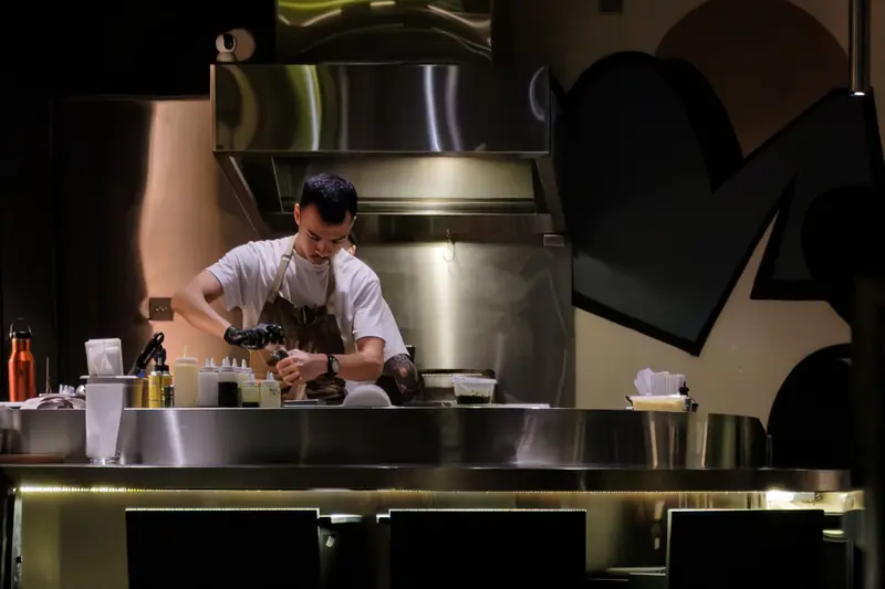Chef al lavoro nella cucina a vista di un ristorante